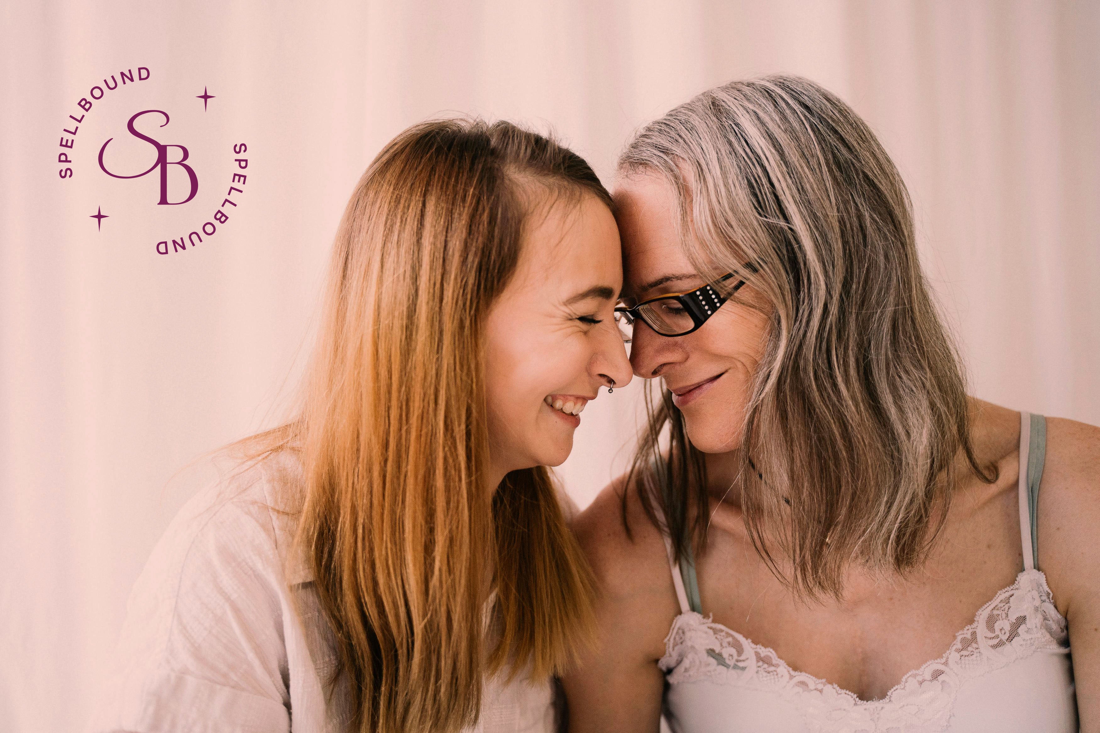 Two people smiling with their foreheads touching with the Spellbound Coaching logo in the corner.